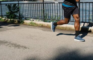 Man-in-Black-Shorts-Running-on-Gray-Concrete