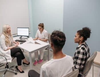 A-Couple-Sitting-at-a-Doctors-Clinic
